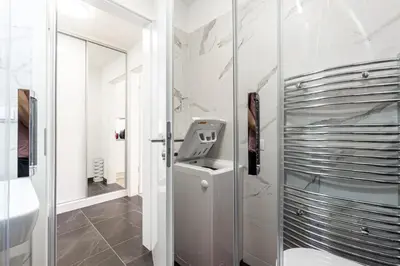 a white bathroom with a sink and a mirror at Minimalist's Dream - sunny cozy studio in New Town in Prague