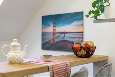 a dining table with a picture of the golden gate bridge at Minimalist's Dream - sunny cozy studio in New Town in Prague