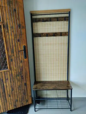 a wooden door and a bench next to a wall at Malé útulné studio s koupelnou a kuchyňkou in Svinařov