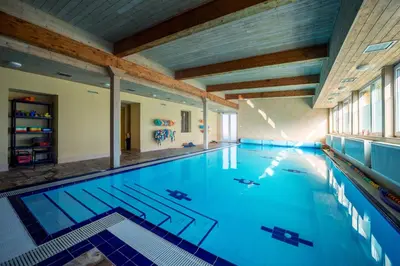 a large indoor swimming pool with blue water at Valnovka Wellness Hotel in Kamenice