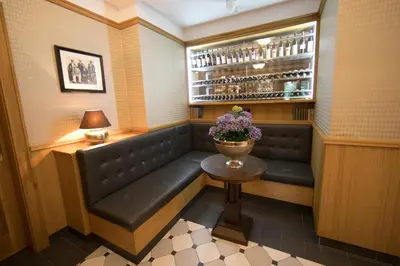 a booth in a restaurant with a table and flowers at Hotel Golfi in Poděbrady