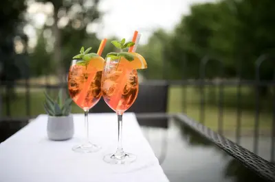two wine glasses with orange cocktails on a table at Hotel Golfi in Poděbrady