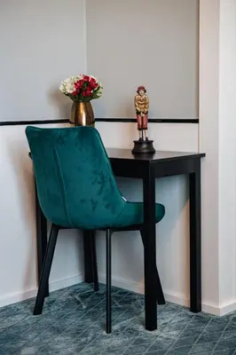 a green chair sitting in front of a desk at Hotel Golfi in Poděbrady
