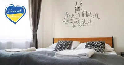 two beds in a bedroom with a sign on the wall at Hostel V38 in Prague