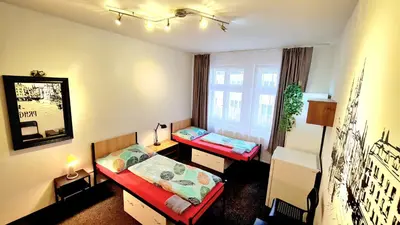 a small room with two beds and a window at Hostel V38 in Prague