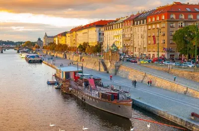 a boat is docked in a river next to buildings at Hostel V38 in Prague
