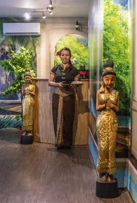 a woman standing next to two statues of women at Hostel V38 in Prague