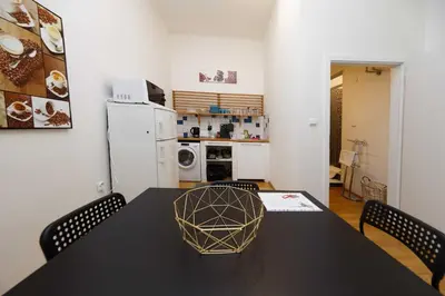 a kitchen with a black table with chairs and a refrigerator at Peter's Tower Apartments in Prague