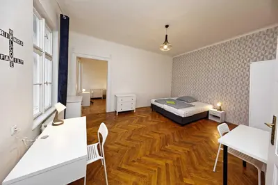 a bedroom with a bed and a wooden floor at Peter's Tower Apartments in Prague