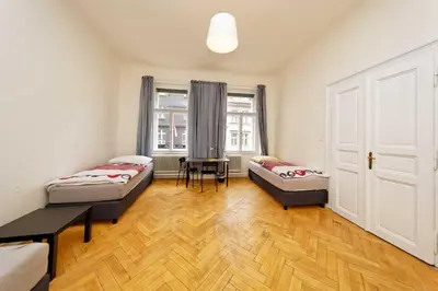 a room with two beds and a table and a window at Peter's Tower Apartments in Prague