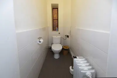 a white bathroom with a toilet and a window at Peter's Tower Apartments in Prague