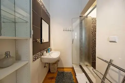 a white bathroom with a sink and a shower at Peter's Tower Apartments in Prague