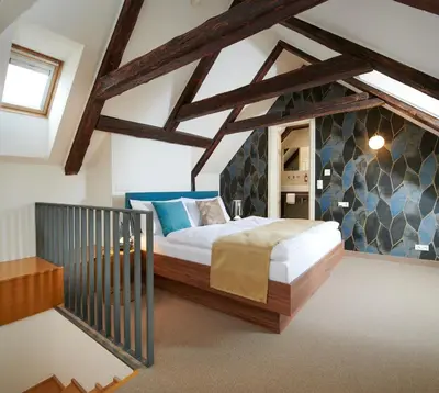 a bedroom with a large bed in a attic at Golden Angel Suites by Adrez in Prague