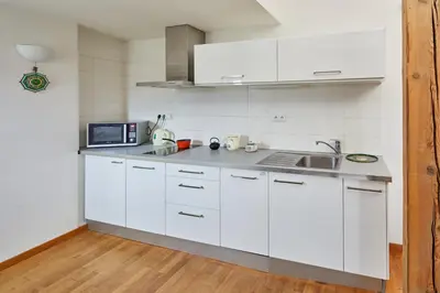 a white kitchen with a sink and a microwave at Prague Days - Loft with Relax Zone near Vltava River in New Town in Prague