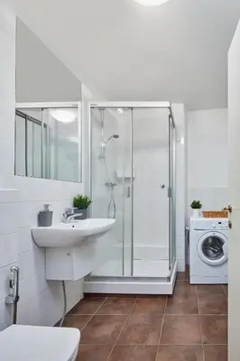 a bathroom with a shower and a sink and a washing machine at Prague Days - Loft with Relax Zone near Vltava River in New Town in Prague
