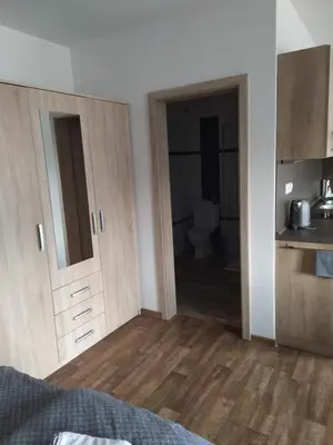 a room with a kitchen with wooden cabinets and a bathroom at Ubytování na statku Račice in Račice