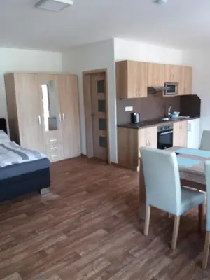 a room with a kitchen and a table and chairs at Ubytování na statku Račice in Račice