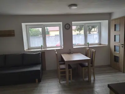 a living room with a table and a couch and windows at Ubytování na statku Račice in Račice
