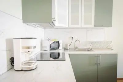 a white kitchen with a coffee maker and a microwave at Apartmán Anastasie in Prague