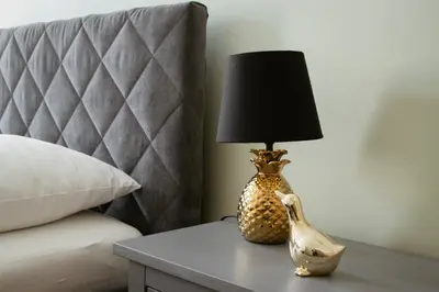 a lamp sitting on a table next to a bed at Apartmán Anastasie in Prague