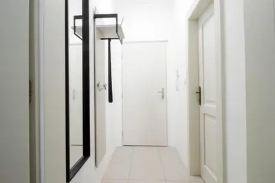 a hallway with white walls and a mirror at Apartmán Anastasie in Prague