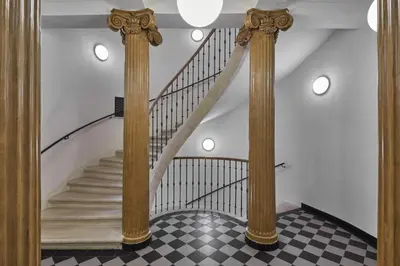 a staircase in a house with columns and a checkered floor at Prague Days - Deluxe Apartments near Wenceslas Square in Prague