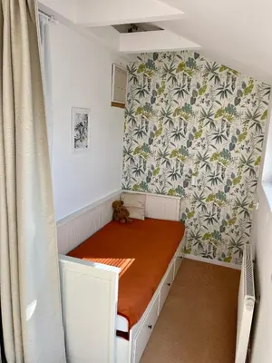 a small bed in a small room with a curtain at Residence Sarka Top in Prague
