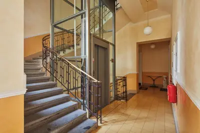 a loft bed in a room with a staircase at Prague Days - One-bedroom Apartment with Balcony and Elevated Chill Zone in Old Town in Prague