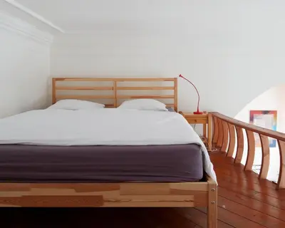 a wooden bed in a bedroom with a wooden floor at Prague Days - One-bedroom Apartment with Balcony and Elevated Chill Zone in Old Town in Prague