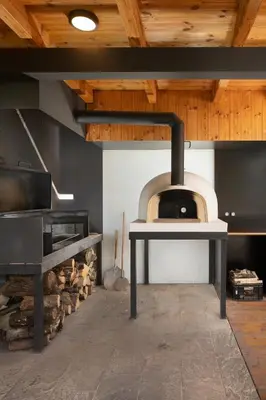 a kitchen with a pizza oven in a room at Smilovický Mlýn in Rakovník