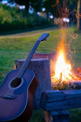 a guitar is sitting next to a campfire at Smilovický Mlýn in Rakovník
