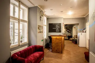 a living room with a red couch and a chalkboard at Ahoy! Hostel in Prague