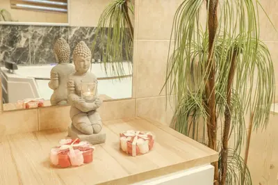 a statue of a person holding a candle in a room with presents at Wellness studio! Finnish sauna, Whirlpool, Gym & more! in Prague