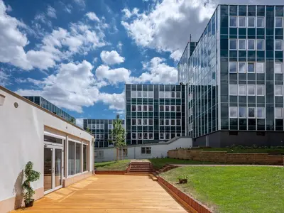 an office building with a wooden walkway in front of it at Wellness studio! Finnish sauna, Whirlpool, Gym & more! in Prague