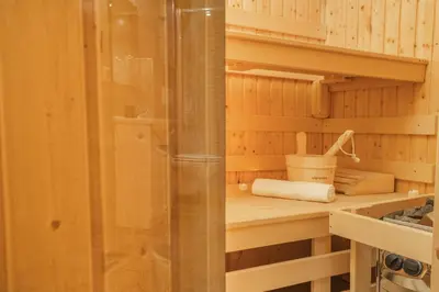 a small kitchen with wooden walls and wooden shelves at Wellness studio! Finnish sauna, Whirlpool, Gym & more! in Prague