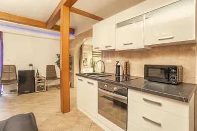 a kitchen with white cabinets and a stove top oven at Wellness studio! Finnish sauna, Whirlpool, Gym & more! in Prague