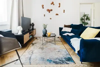 a living room with a blue couch and a tv at Prague Days - One-bedroom Apartment with Netflix and Workspace with iMac in New Town in Prague
