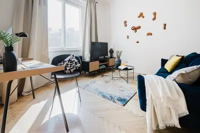 a living room with a blue couch and a tv at Prague Days - One-bedroom Apartment with Netflix and Workspace with iMac in New Town in Prague
