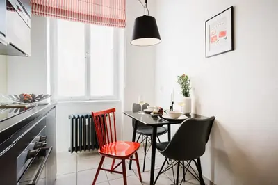 a kitchen with a table and chairs in a room at Prague Days - One-bedroom Apartment with Netflix and Workspace with iMac in New Town in Prague