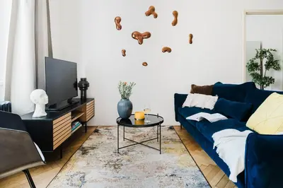 a living room with a blue couch and a tv at Prague Days - One-bedroom Apartment with Netflix and Workspace with iMac in New Town in Prague