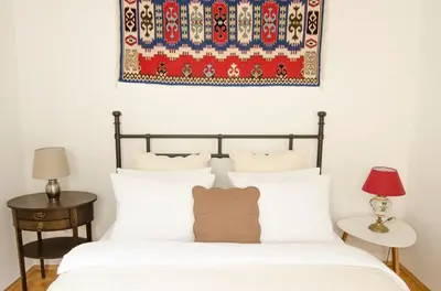a bedroom with a bed and a rug on the wall at Wishlist Prague Residences - Charles Bridge Karlova in Prague