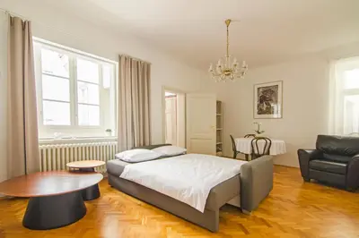 a bedroom with a bed and a table and a chair at Wishlist Prague Residences - Charles Bridge Karlova in Prague