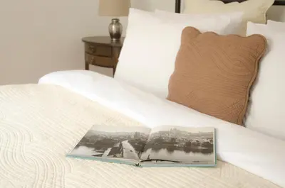 a book sitting on top of a bed at Wishlist Prague Residences - Charles Bridge Karlova in Prague