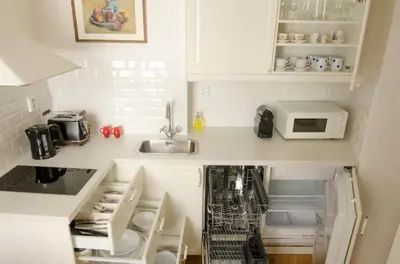 a small kitchen with white cabinets and a sink at Wishlist Prague Residences - Charles Bridge Karlova in Prague