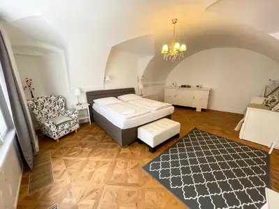 a bedroom with a bed and a chair in a room at U Obecního dvora - Old Town Apartment in Prague