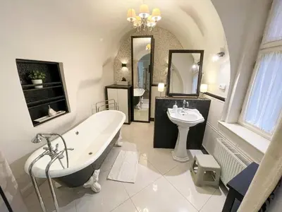 a white bathroom with a tub and a sink at U Obecního dvora - Old Town Apartment in Prague
