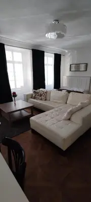a living room with a large white couch and tables at U Obecního dvora - Old Town Apartment in Prague