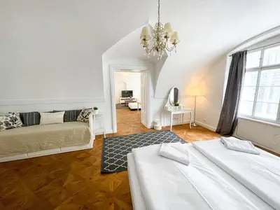 a bedroom with two beds and a living room at U Obecního dvora - Old Town Apartment in Prague