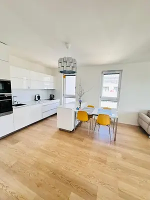 a kitchen and dining room with a table and yellow chairs at Nová Nuselská in Prague