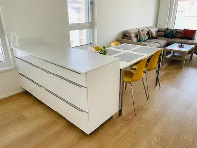 a kitchen with a white island in a living room at Nová Nuselská in Prague